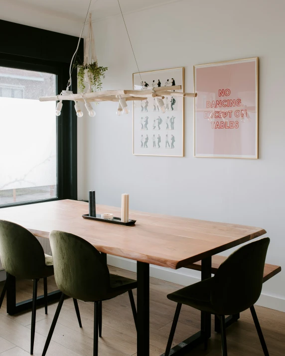 a dining table with green chairs in front of a window