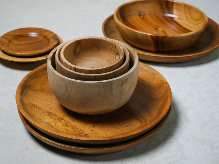 several wooden dishes that are stacked on a counter