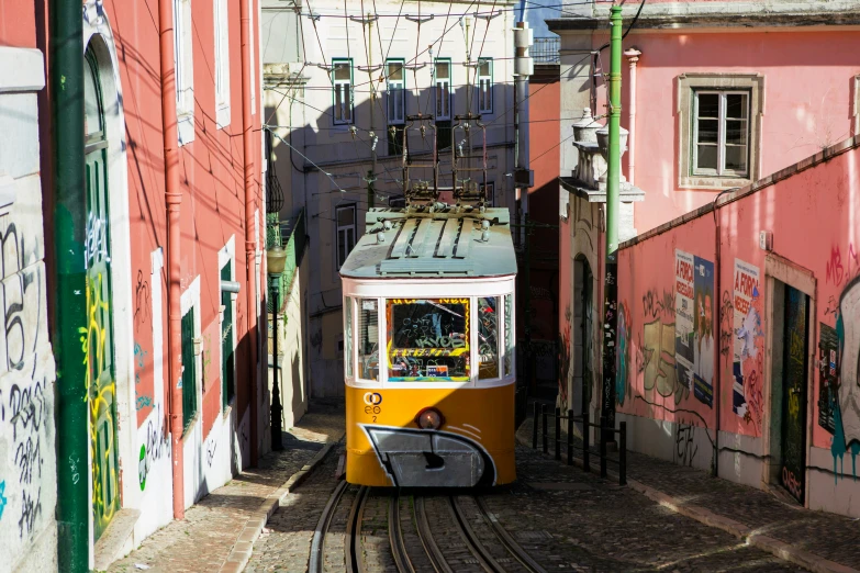 the yellow trolley drives down the tracks of the alley