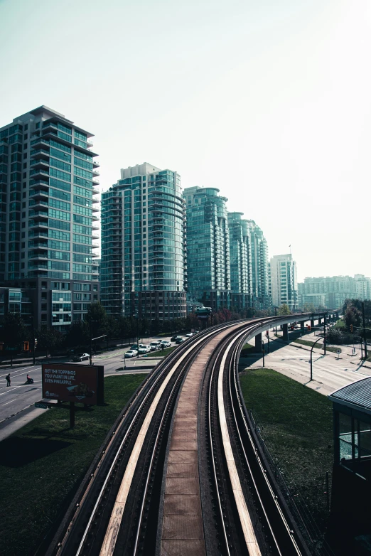 an overhead view of some city buildings with railroad tracks