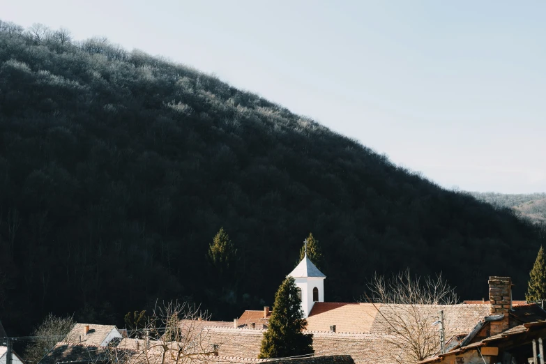 an old building on the corner of a hill near a mountain