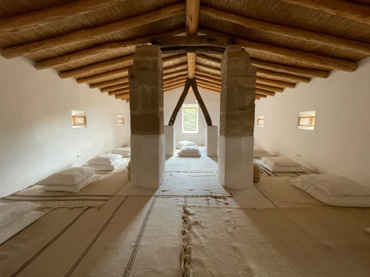 an empty hallway leads to another large bedroom