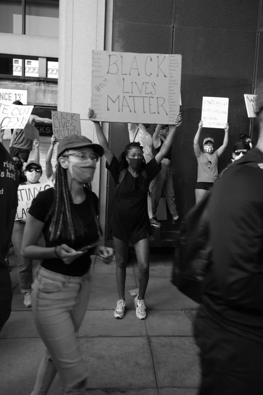 a woman holding a sign while others hold signs