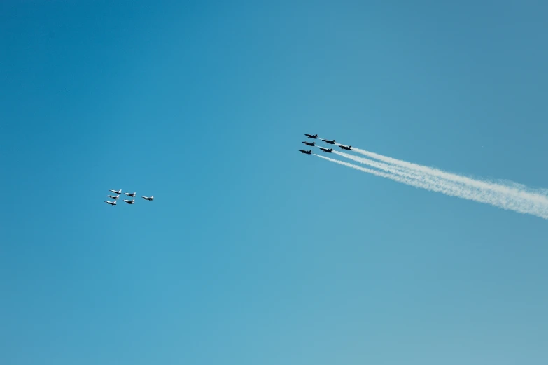 a formation of fighter jets flying through a blue sky