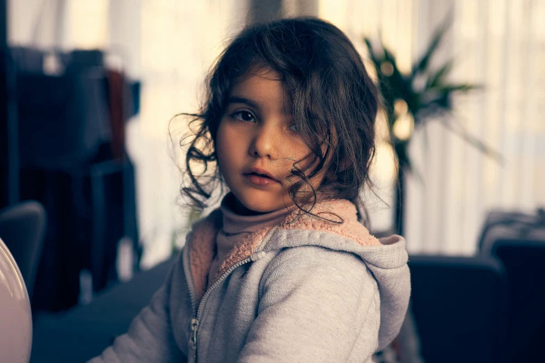 a little girl looking at the camera with light coming through her hair