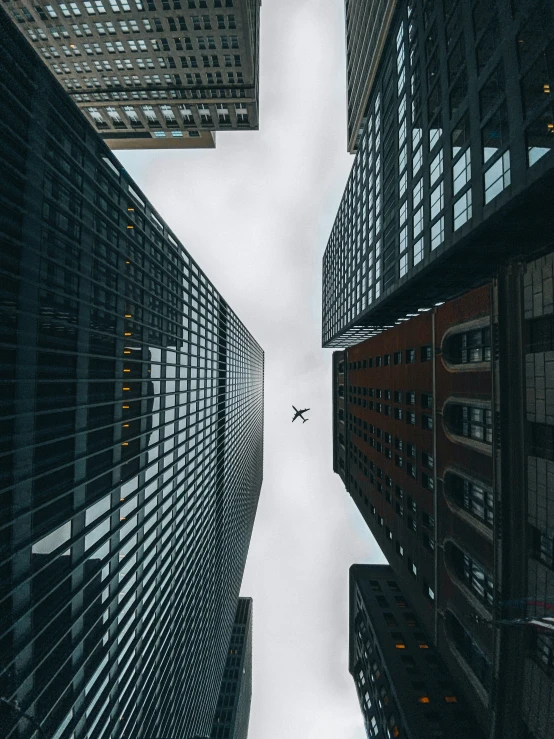 a plane flying in between two tall buildings