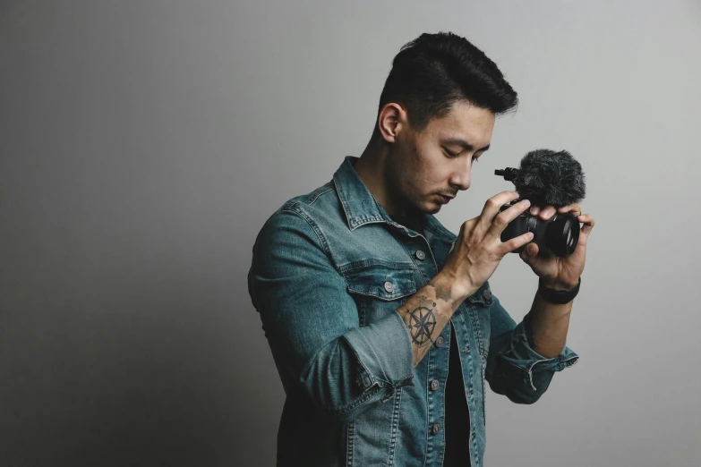 a man holds an old style camera and takes a po