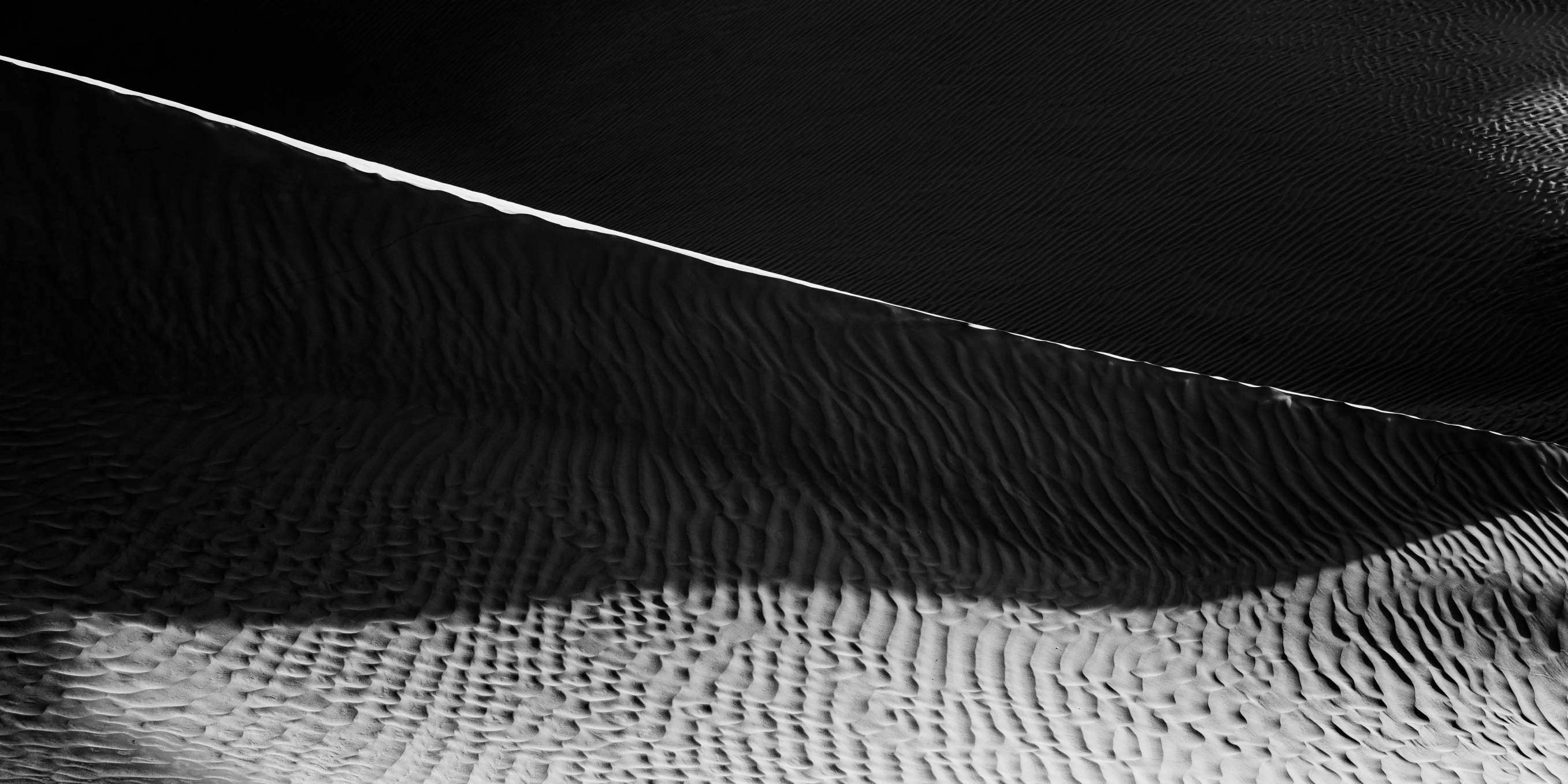 the dark and white pograph shows texture of sand and water