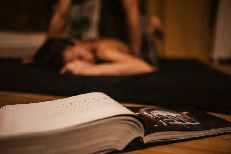 a close up view of an open book on a table with people in the background
