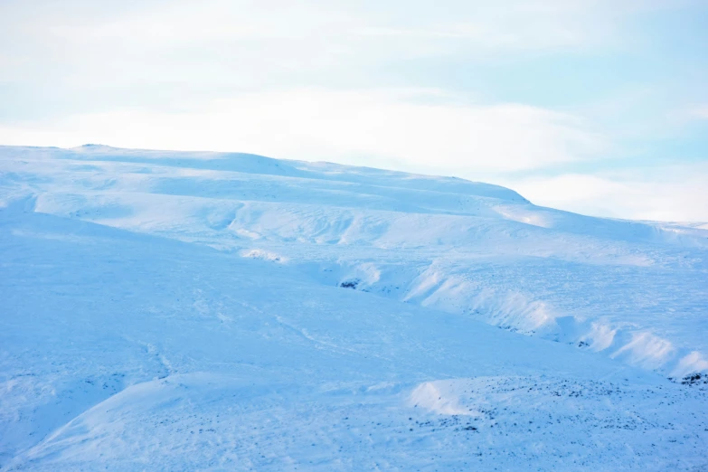 a single person is on the side of a snowy hill