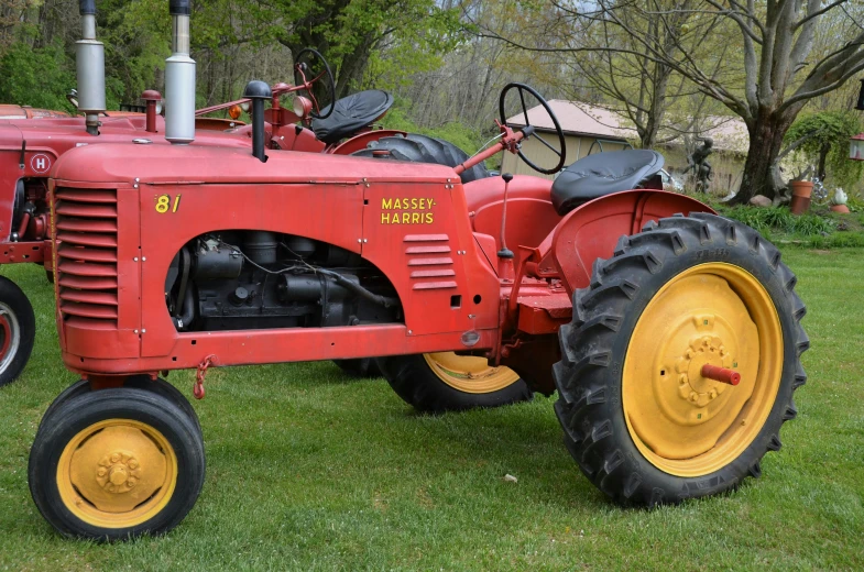 a red tractor with four tires on a green field