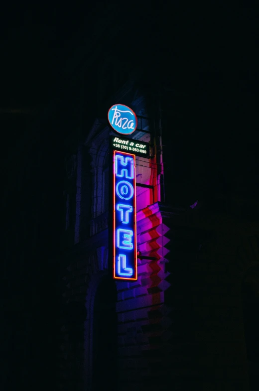 neon sign on brick building advertising motel