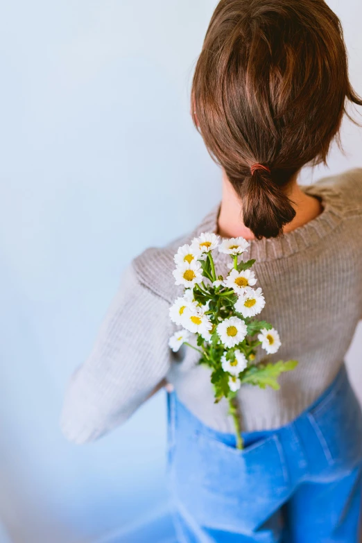 a person wearing a gray sweater with white flowers