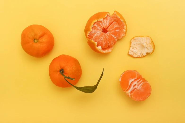 oranges with peeling and seeds on a yellow background