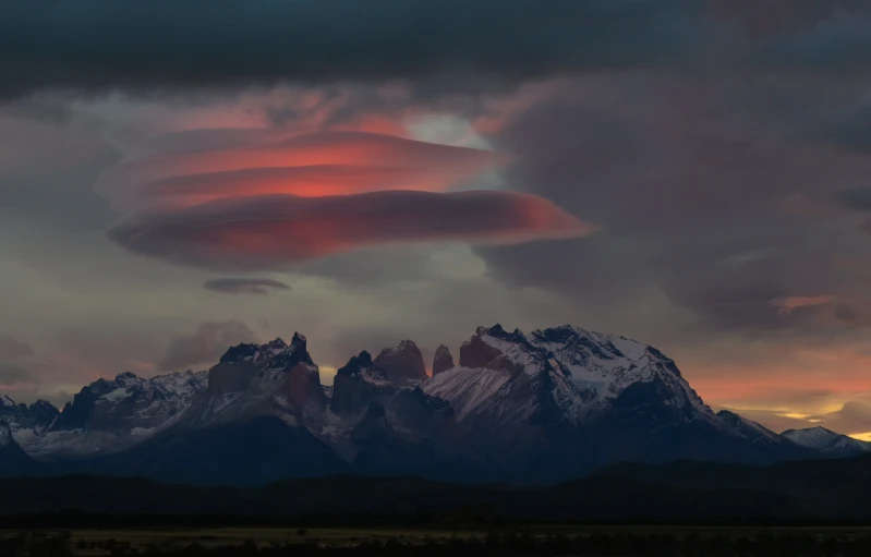 a majestic landscape po with pink clouds above a mountain range