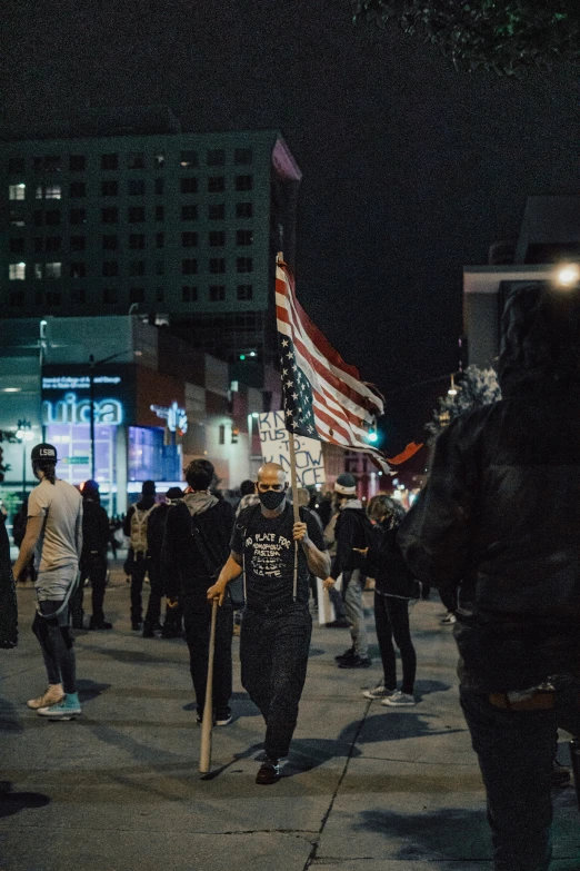 a group of people walking down the street holding flags