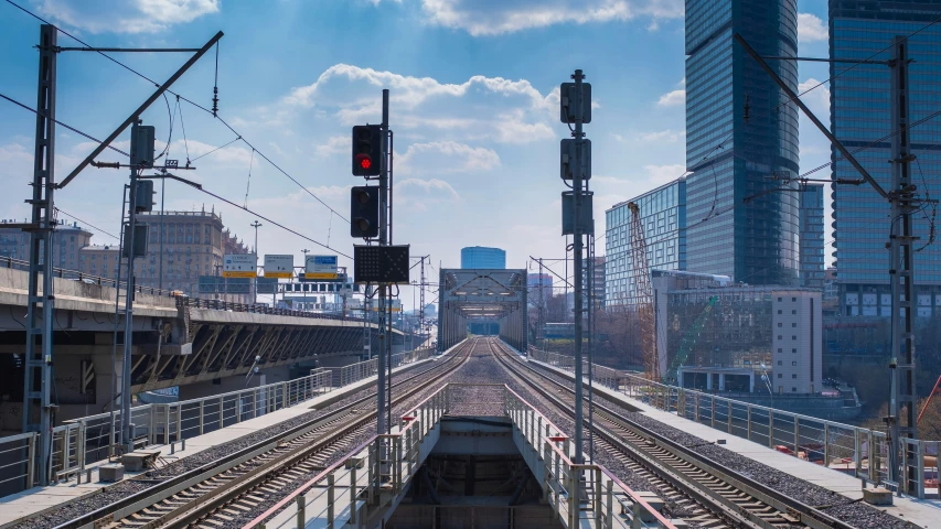 a train track running parallel to several buildings in the background