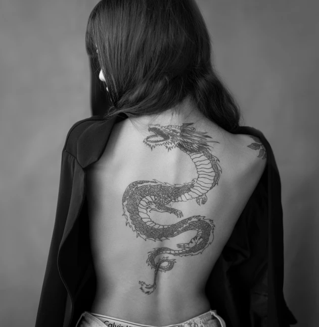 a woman has tattoos on her back