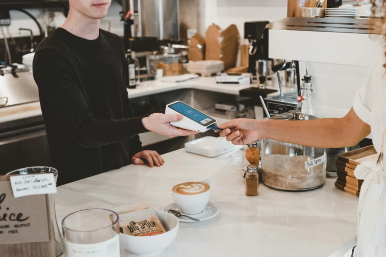 a woman is handing soing to a man on the counter