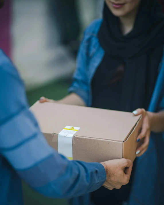 a person giving a pizza to another man