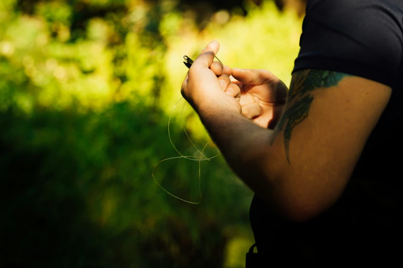 a person with a tattoo looking at their cell phone