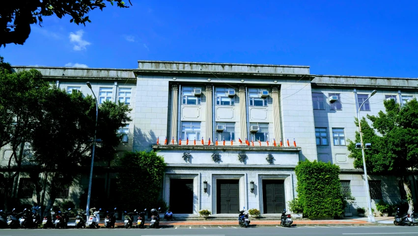 people on motorcycles parked outside an old building