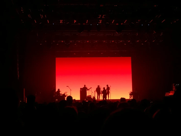 the silhouette of some people standing on stage