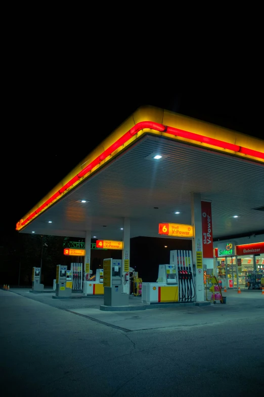 a gas station at night with lit up fuel pumps