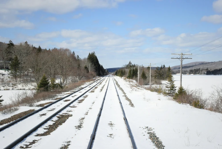 a train track going across snow covered ground
