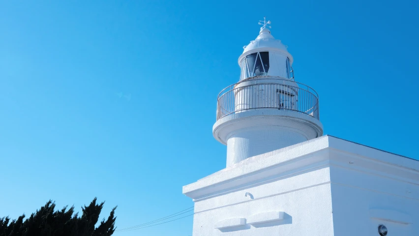 a white lighthouse has a clear sky above it