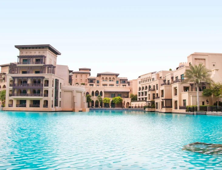 a large resort with an abundance of buildings next to a blue pool