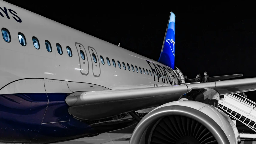 airplane parked on a runway at night with blue trim