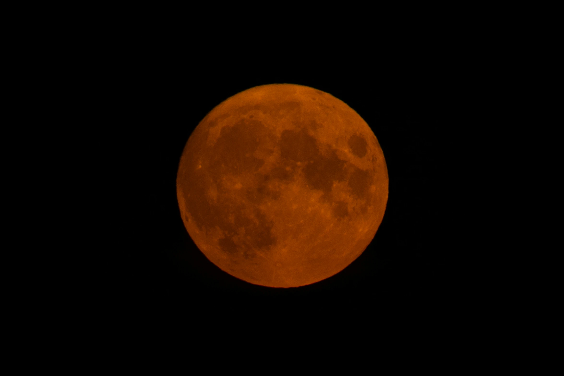 a bright red moon is in the night sky