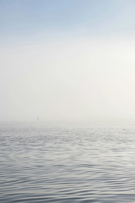 a large body of water sitting on top of a foggy day