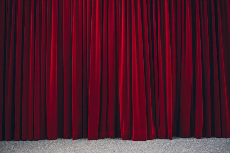 a red curtain with dark colored folds on it