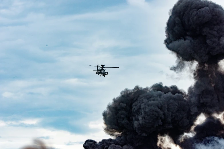 a helicopter flying in front of a bunch of fire