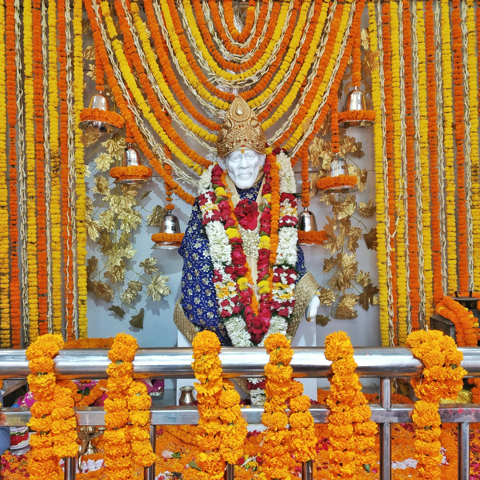 a statue of a god decorated with golden, orange and white decorations