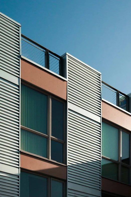 the side of a building with glass windows and balconies