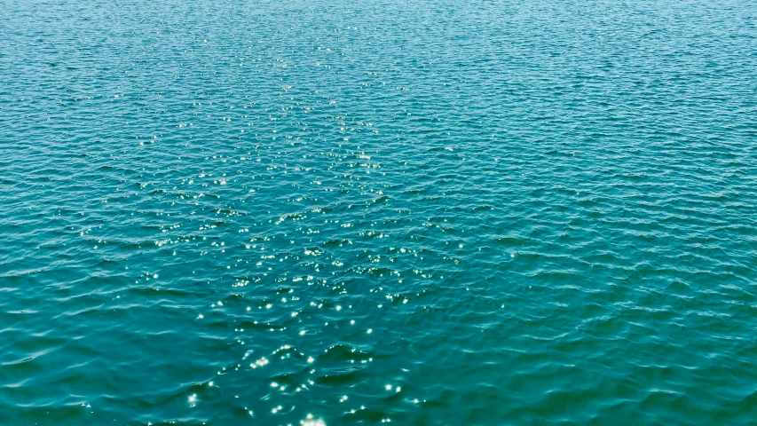 the blue water has tiny bubbles as it flows into the surface