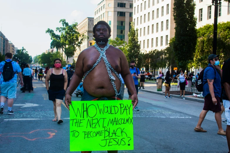 a man in chains holds a sign that says not amused the next woman to remove back