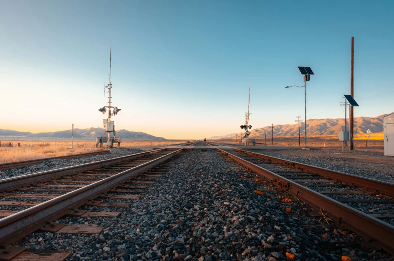 two sets of railroad tracks going through a desert