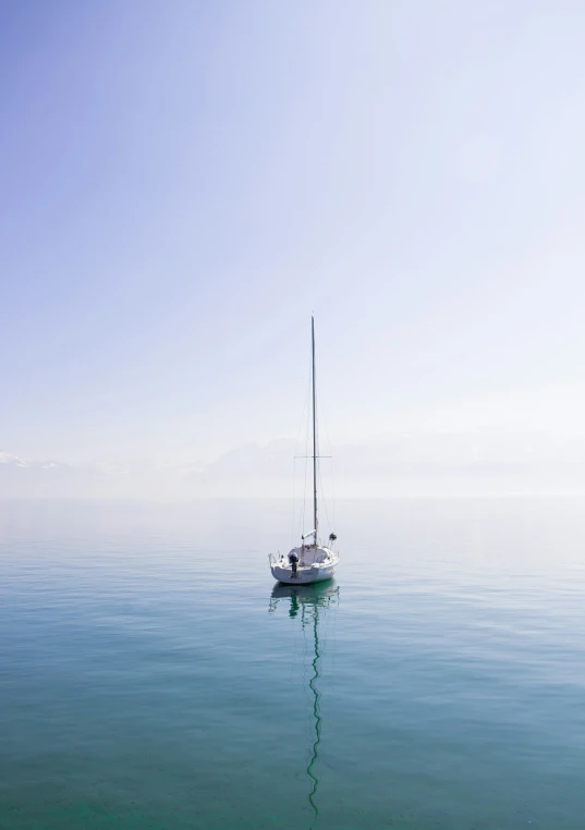 a white boat is floating in the middle of the ocean