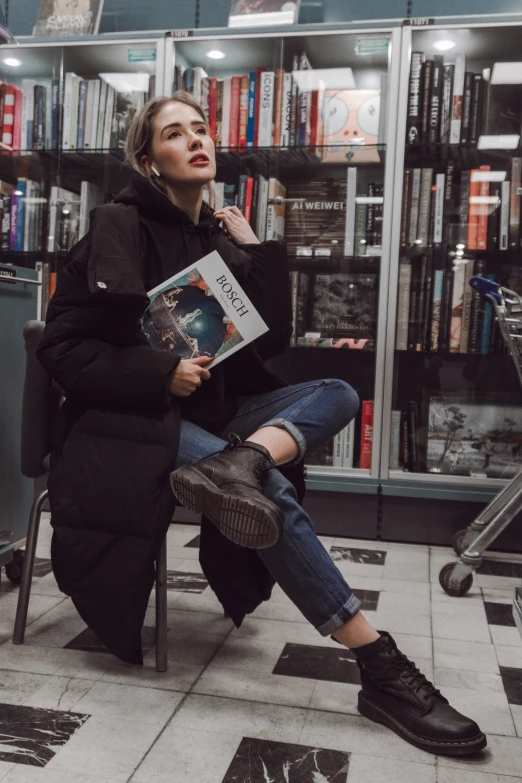 a woman reading sitting in a chair and looking at a book