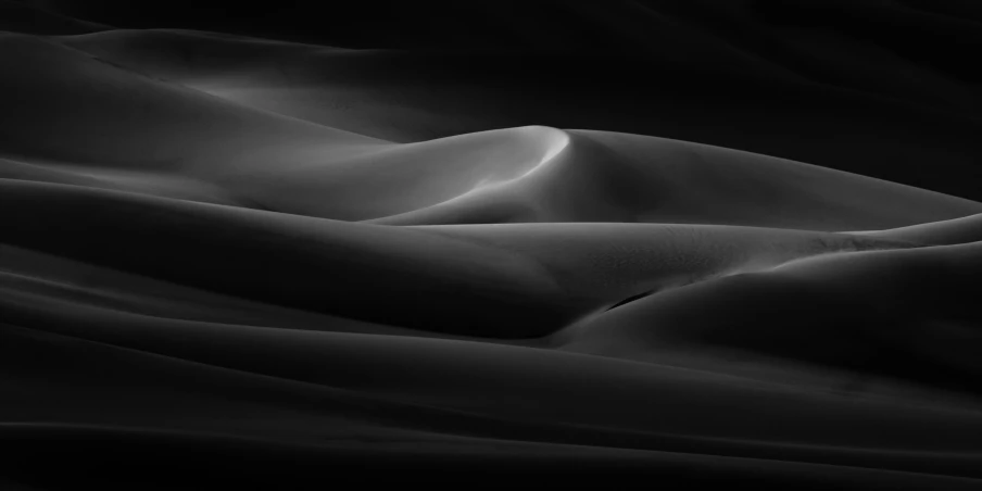 a large, black and white pograph of sand dunes