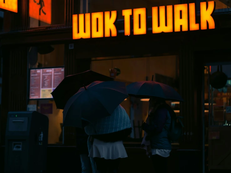 two people holding umbrellas in front of a building