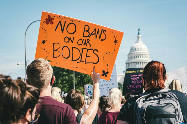 two people holding signs in front of the us capitol building