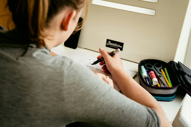 a person at a desk with a bag of pencils