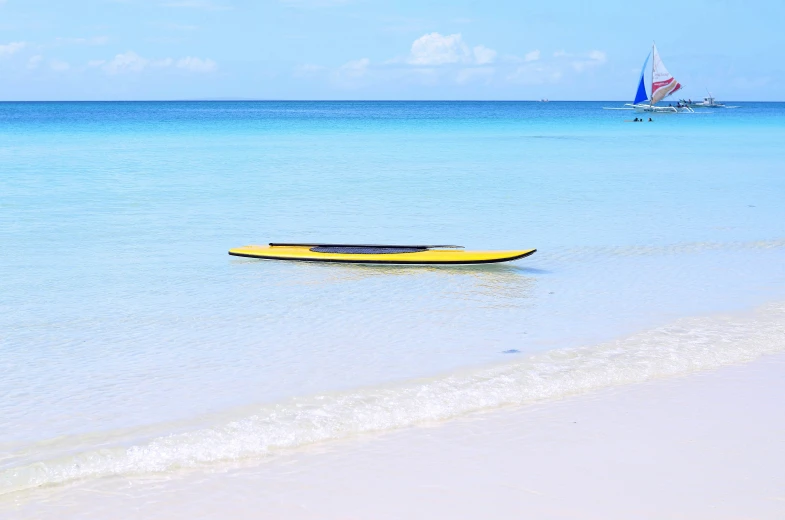 a small yellow boat is tied to a pole on the shore line