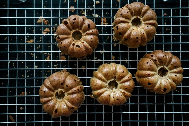four bundts with holes sitting on a cooling rack