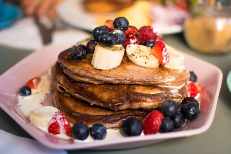 the stack of pancakes is covered with fruit